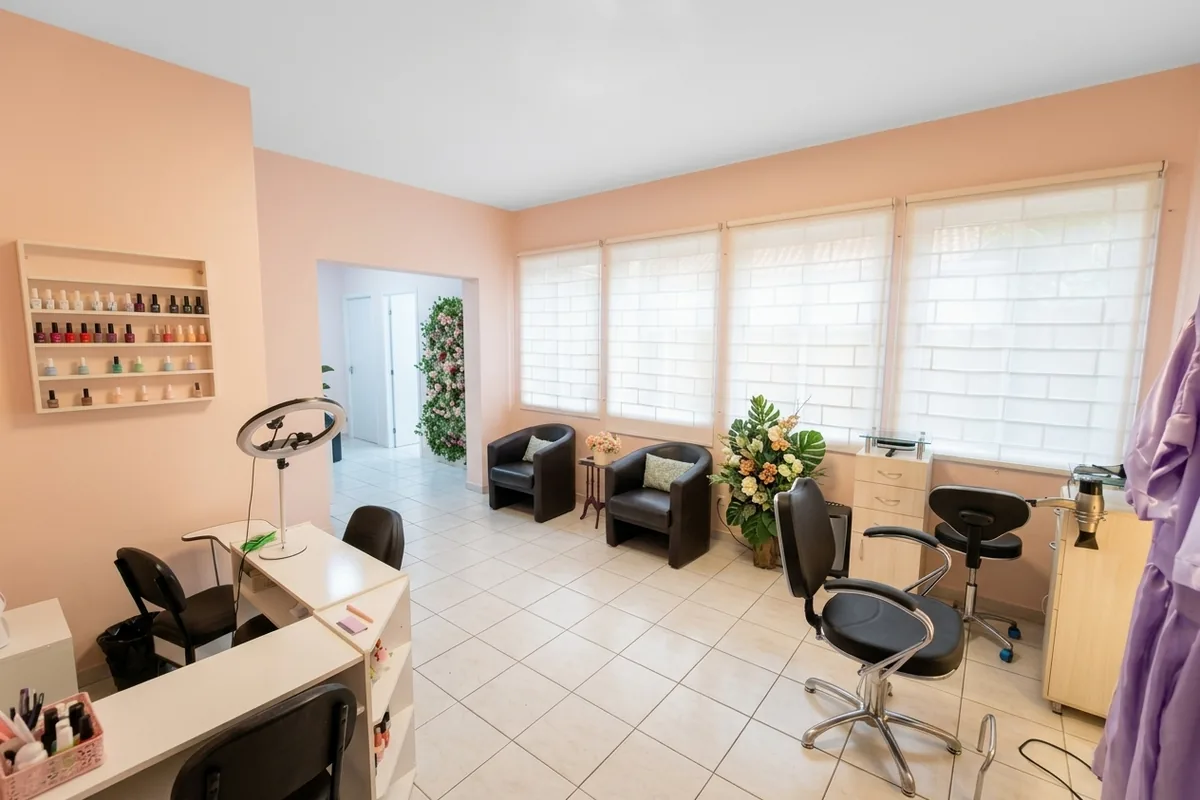 Salão do estúdio Marcela De Simone no Juvevê: cadeira de corte, poltronas de espera, bancada de manicure e janelas com luz natural